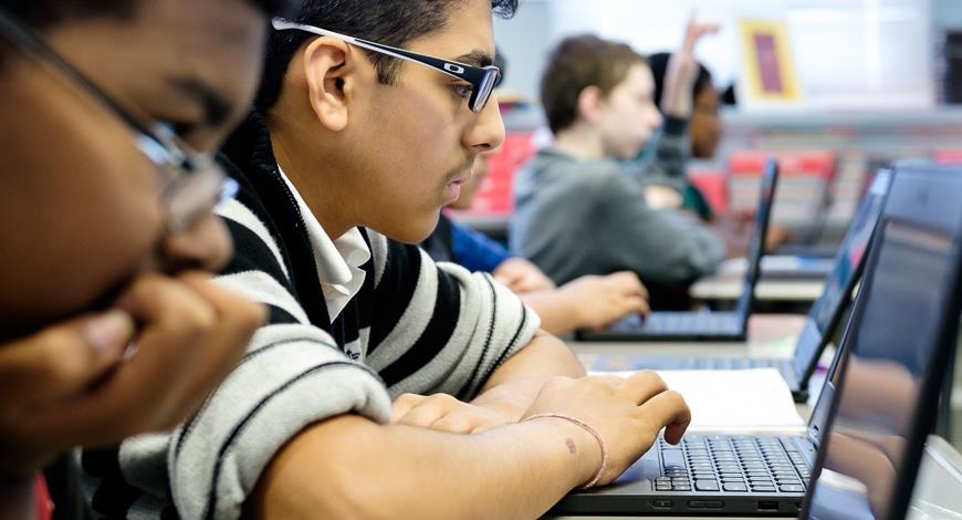 Students working on laptops during class. 